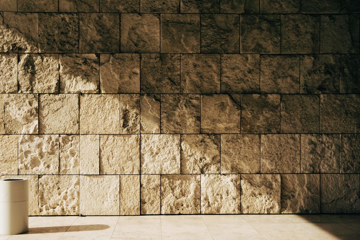 A wall of large, pale limestone blocks catching warm, low sunlight.